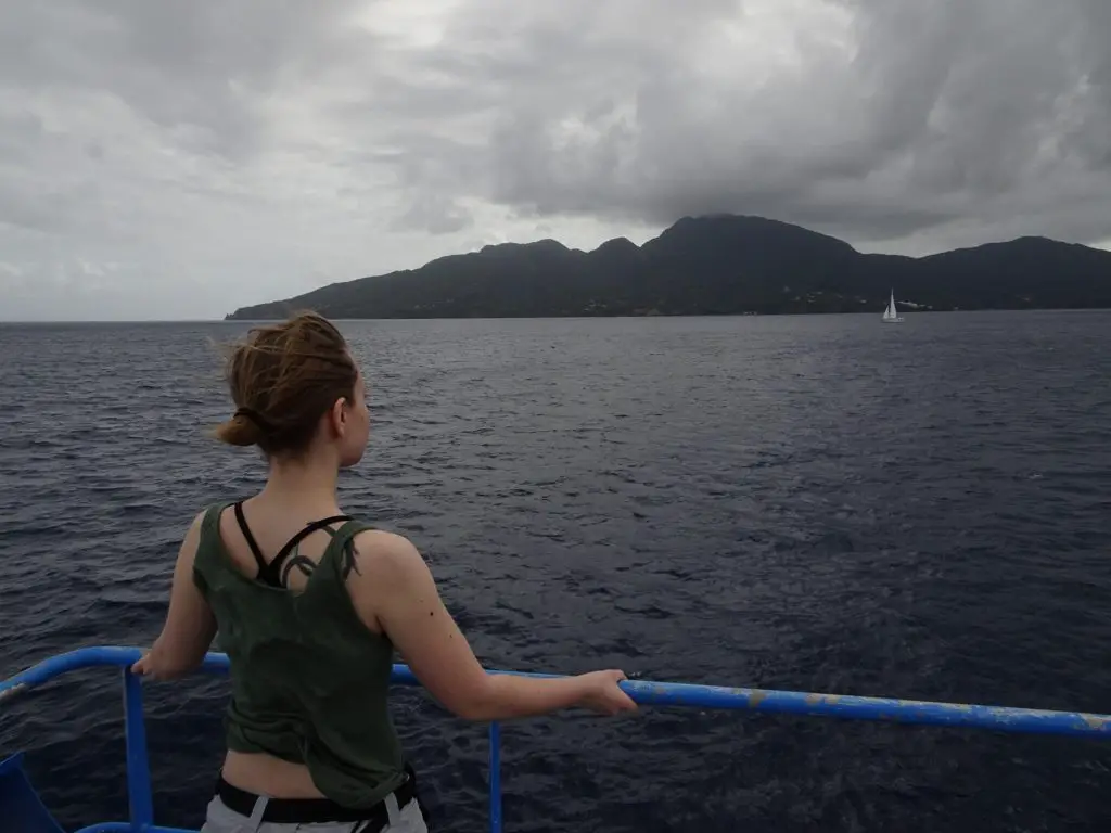 A woman looking at the coastline of Dominica from a ferry