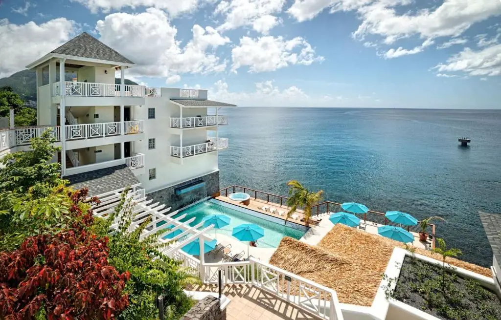 ein Gebäude mit einem Pool am Meer in der Unterkunft Fort Young Hotel in Roseau