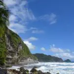 A beautiful tropical beach with a waterfall going directly into the ocean at Wavine Cyrique, Dominica