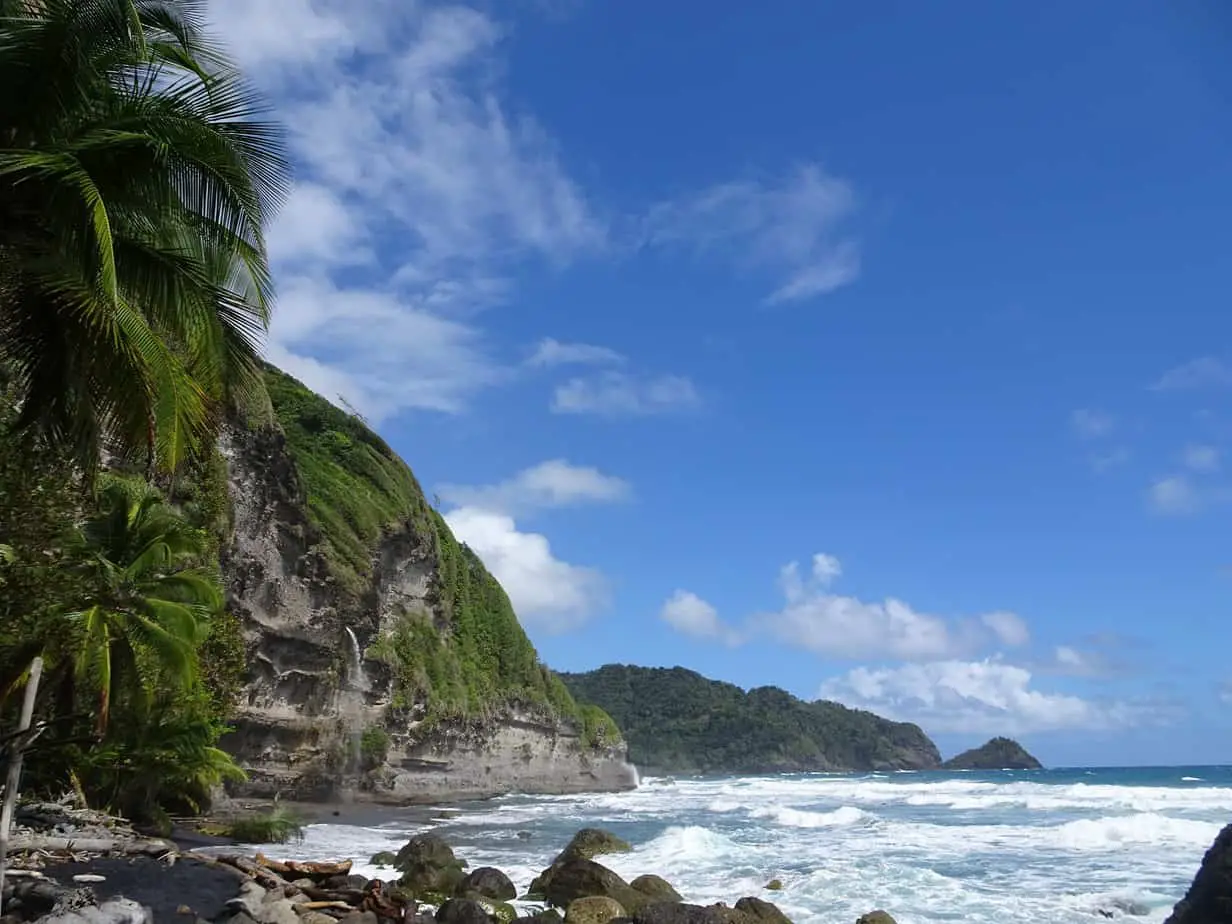 A beautiful tropical beach with a waterfall going directly into the ocean at Wavine Cyrique, Dominica