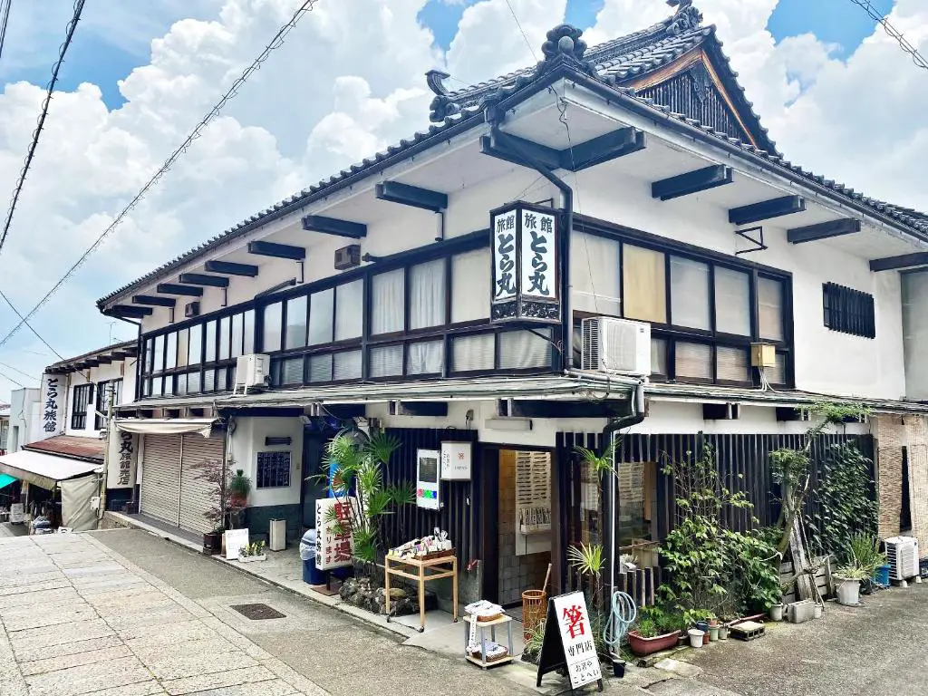 ein Gebäude mit einem Schild davor in der Unterkunft Toramaru Ryokan in Kotohira