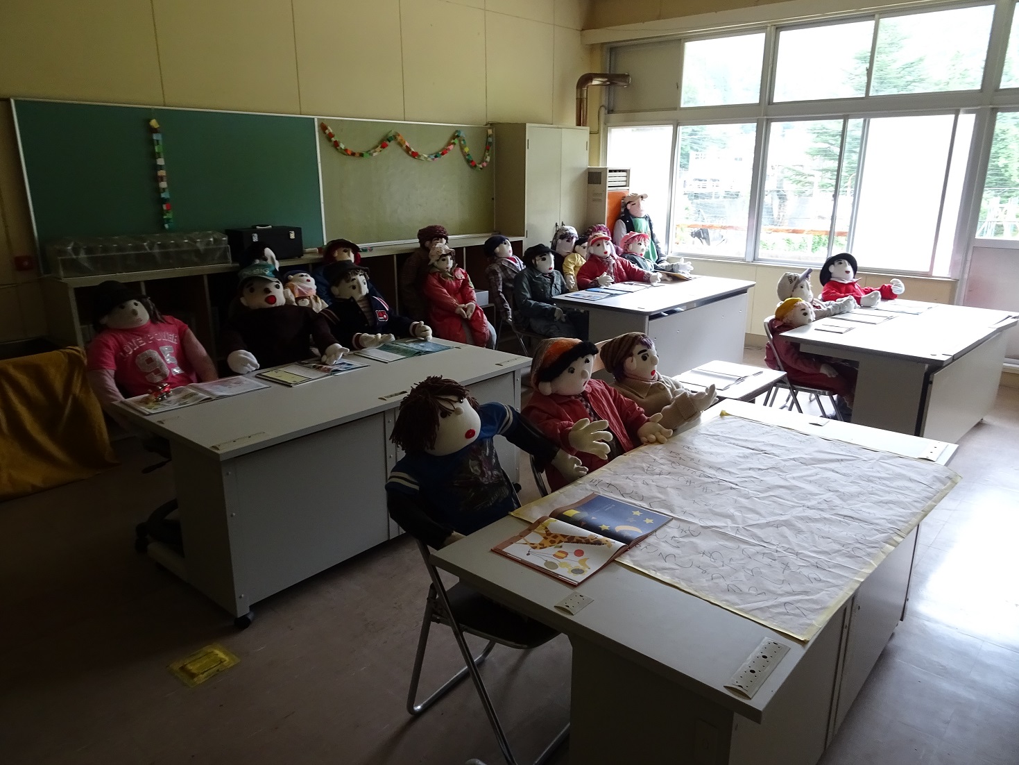 Life-sized puppets sitting in a class room