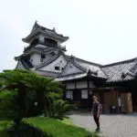 A girl standing in front of a traditional Japanese castle keep