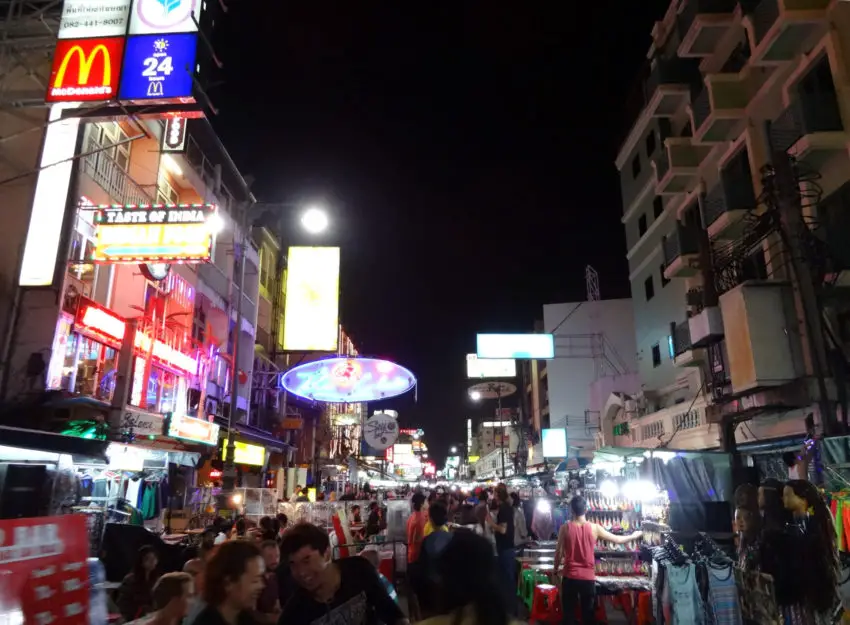 A brightly lit street populated by countless people