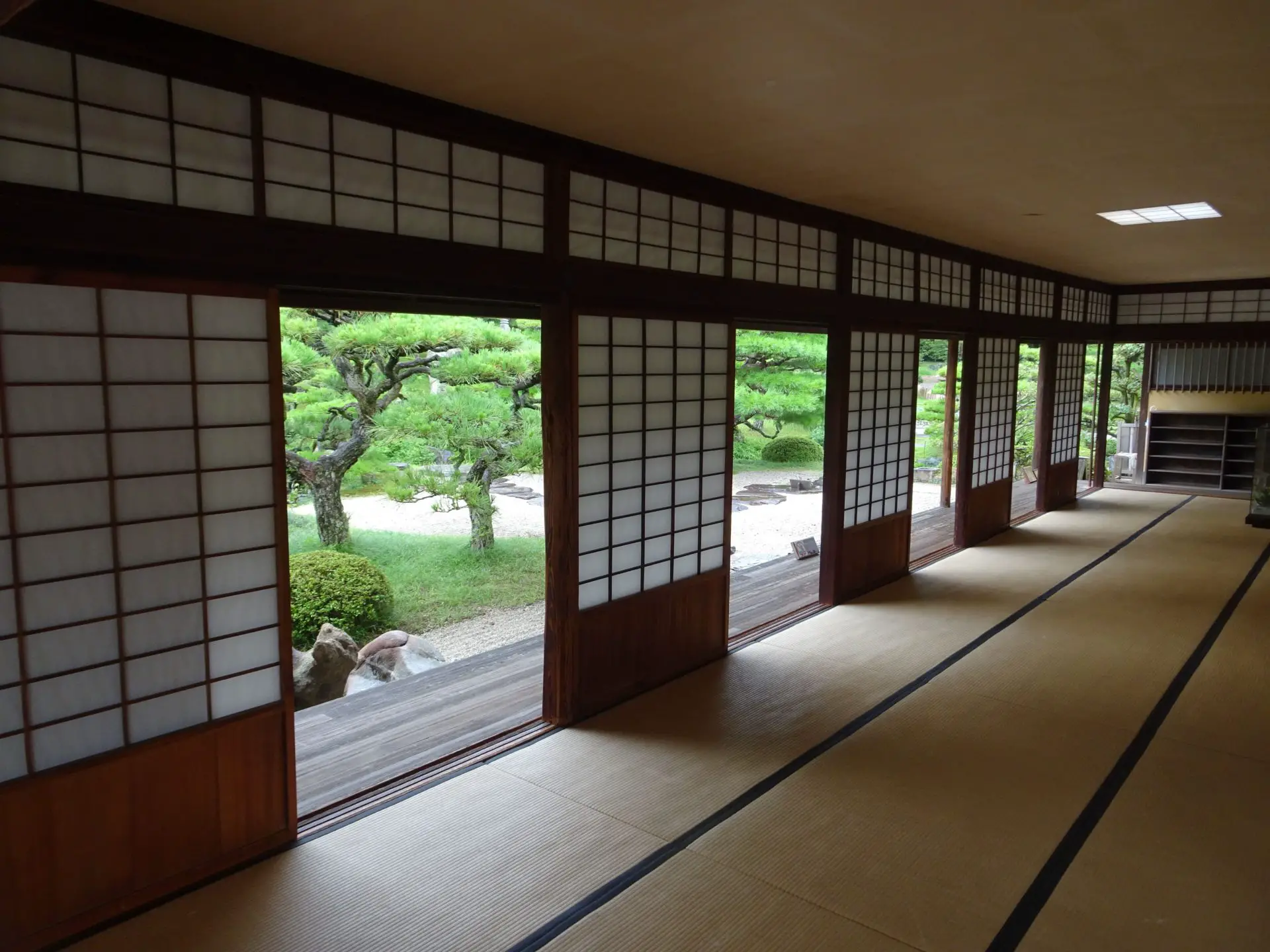 Openings in a tea house wall showing a Japanese garden