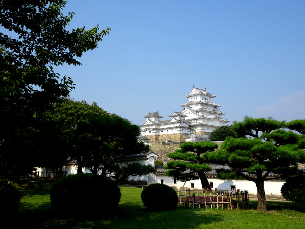 A towering wooden castle keep seen from a garden