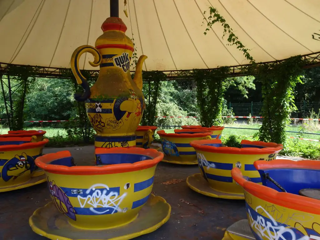 A dilapitated spinning-cups-ride under a tent