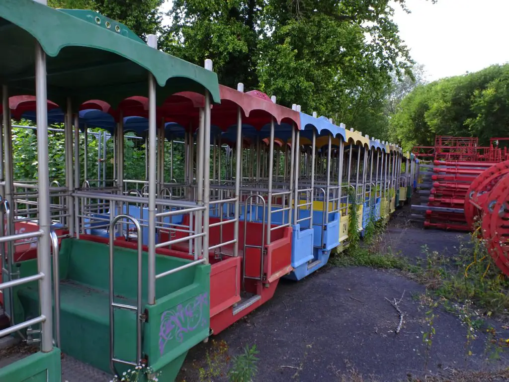 A series of colourfull ferris wheel cabins standing disassembled on the ground