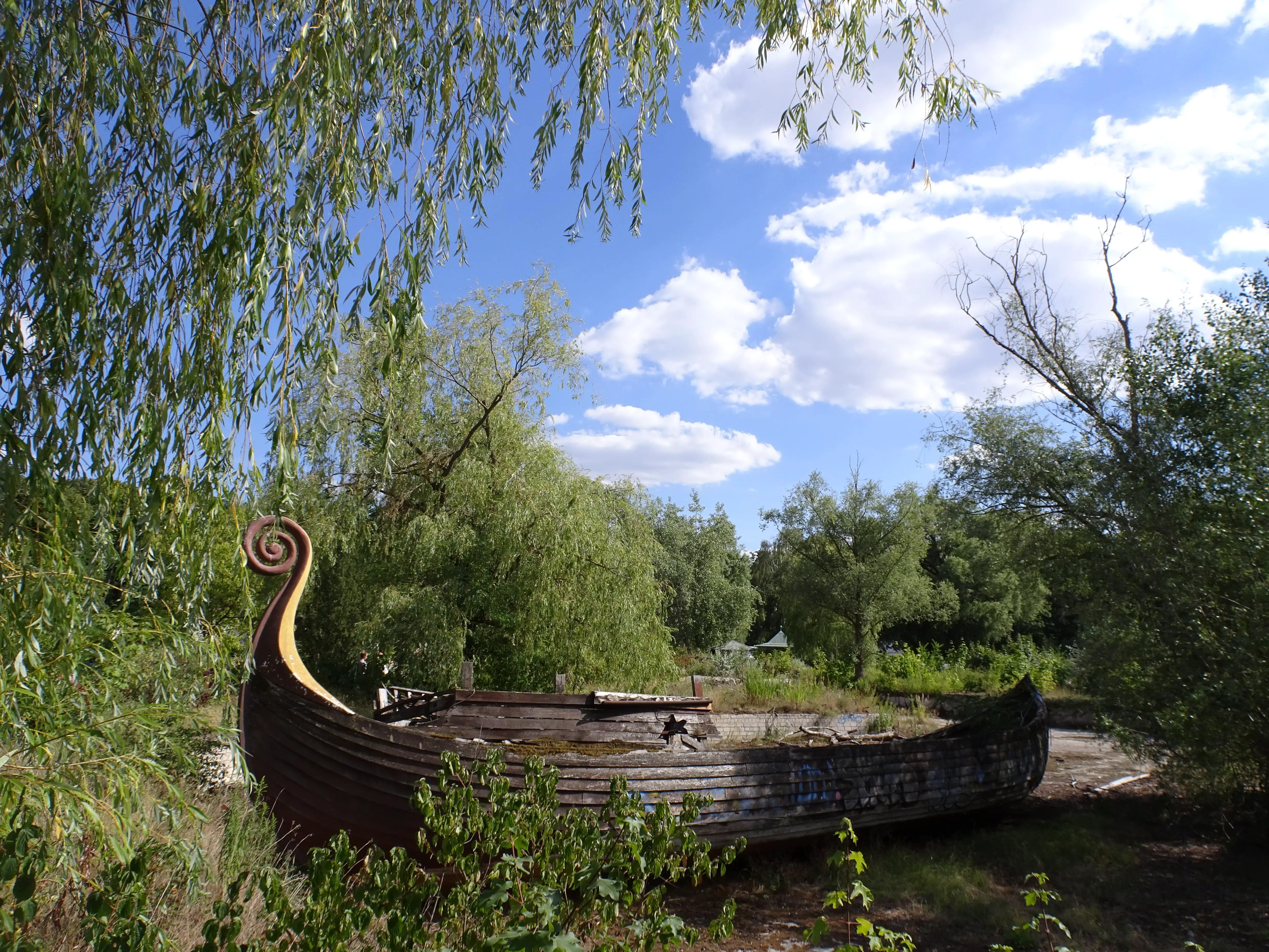 A wooden boat lying in a dry pond