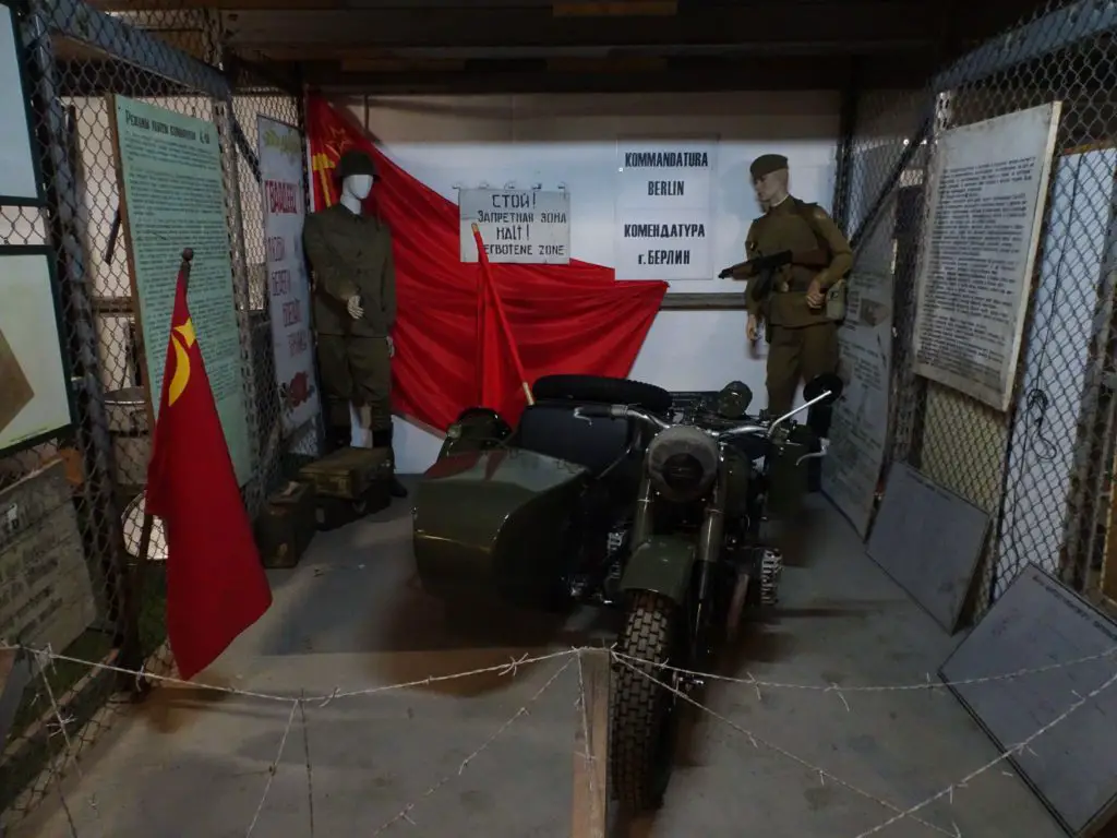 Wax figures of soldiers and a military motorcycle in a museum