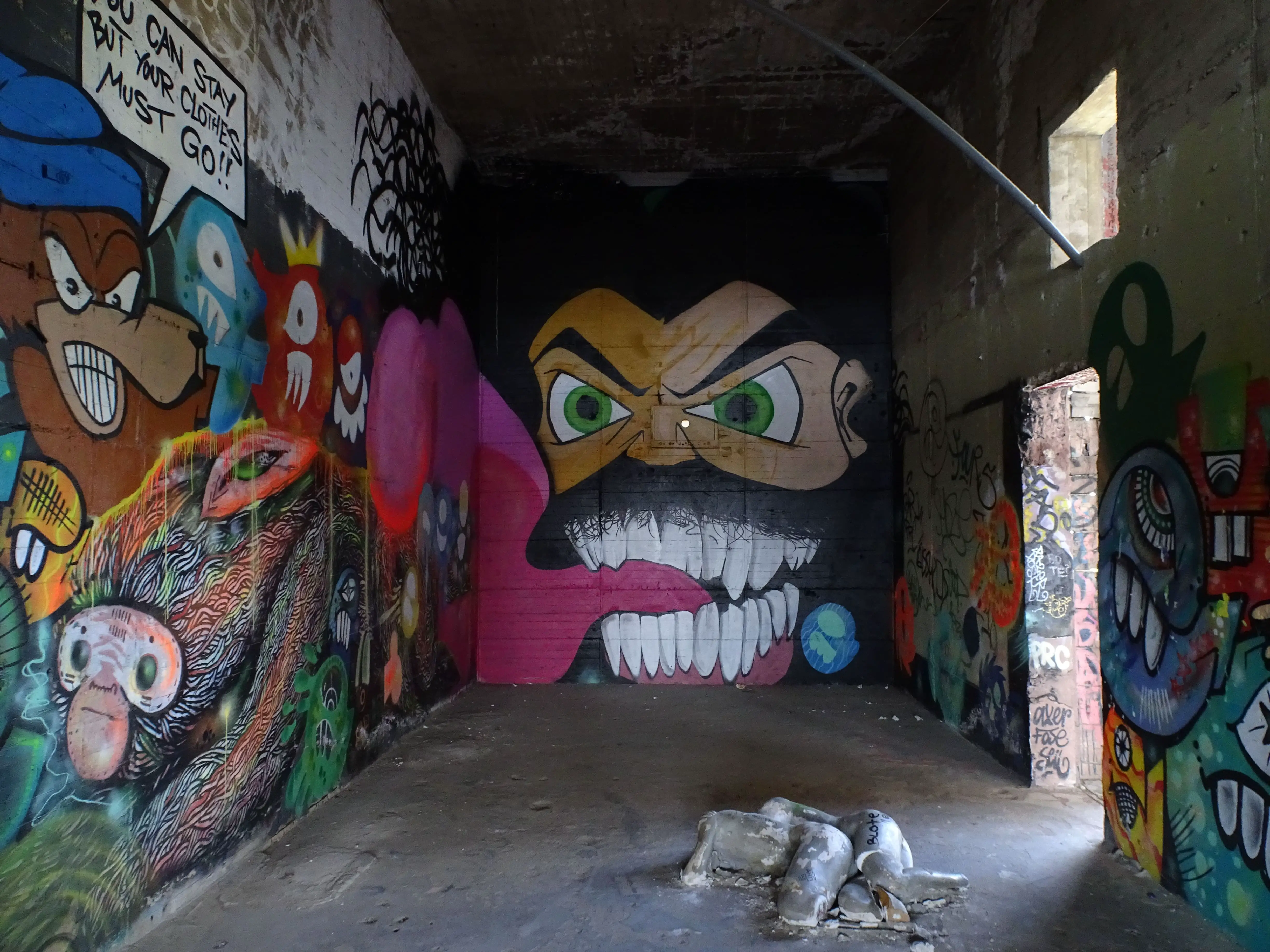 A graffiti of a grinning bearded man in a dark room