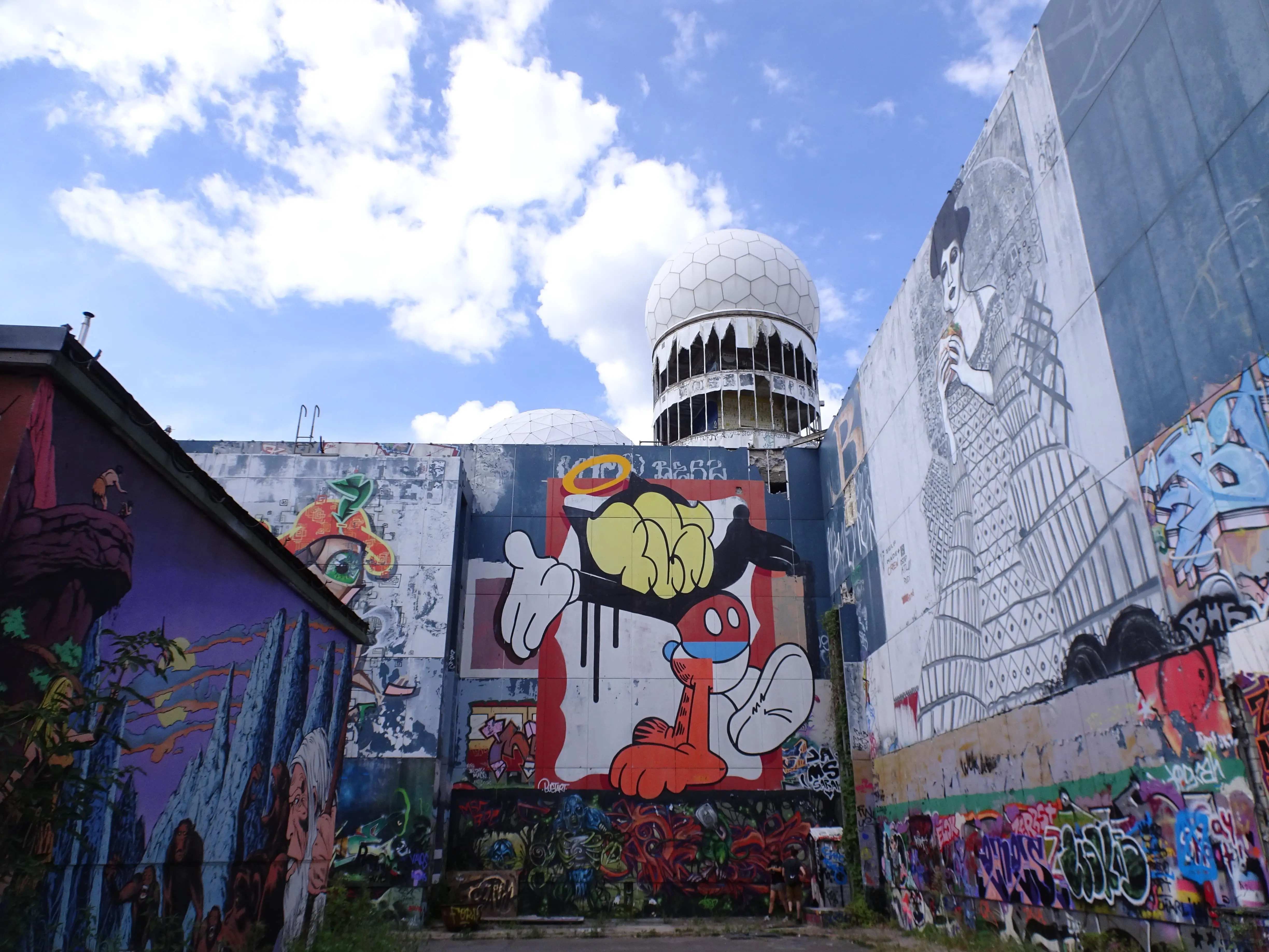 A domed building over a wall covered in graffiti