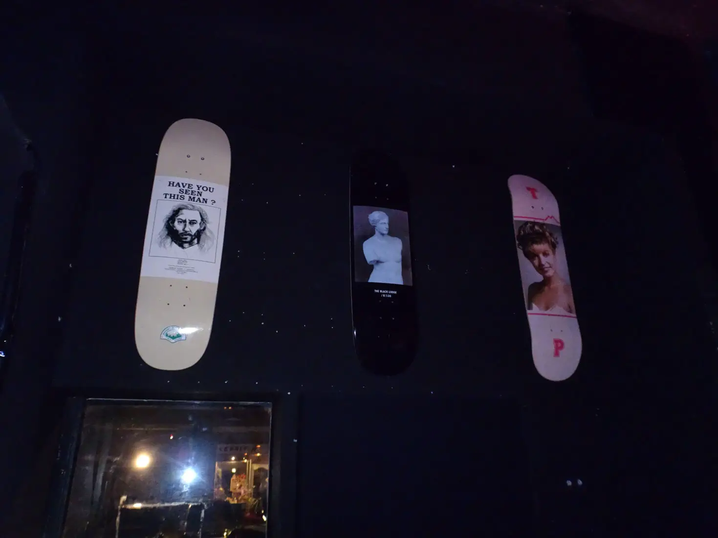 Skateboards with pictures hung up on the wall