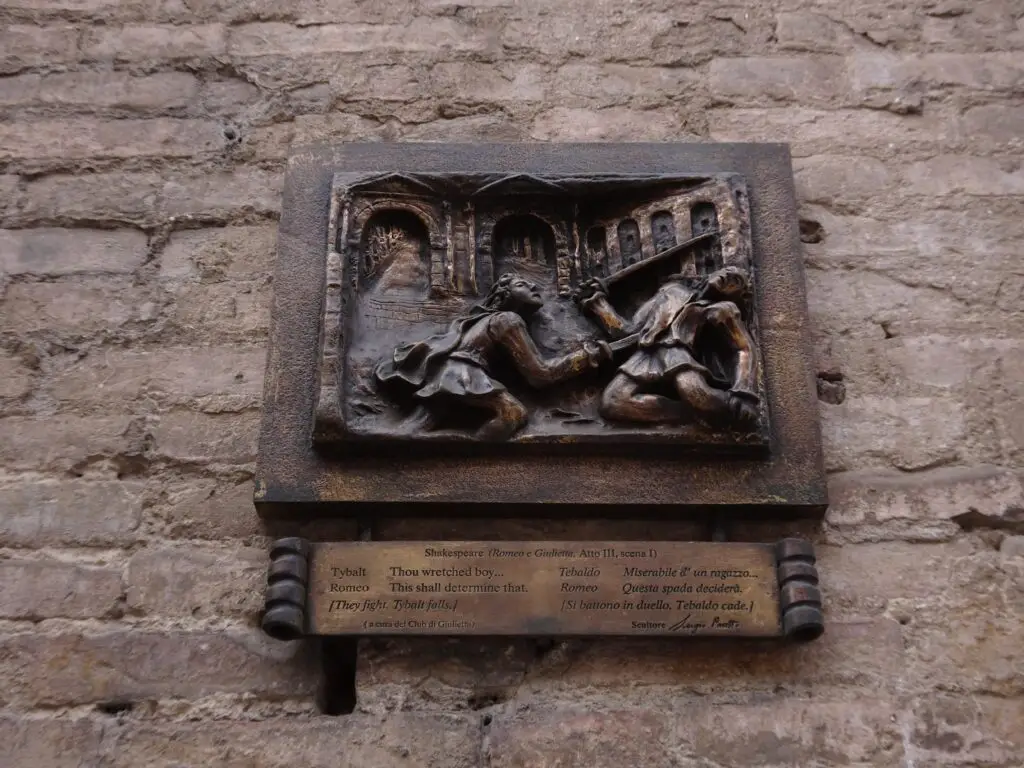 A metal plaque depicting a man stabbing another man