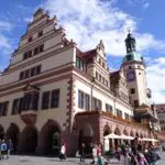 A renaissance-style city hall with people passing on foot