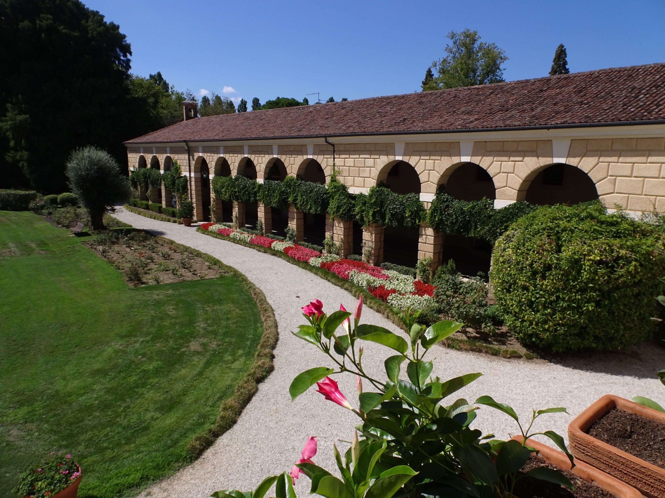 An arcaded walkway with flowers in the foreground