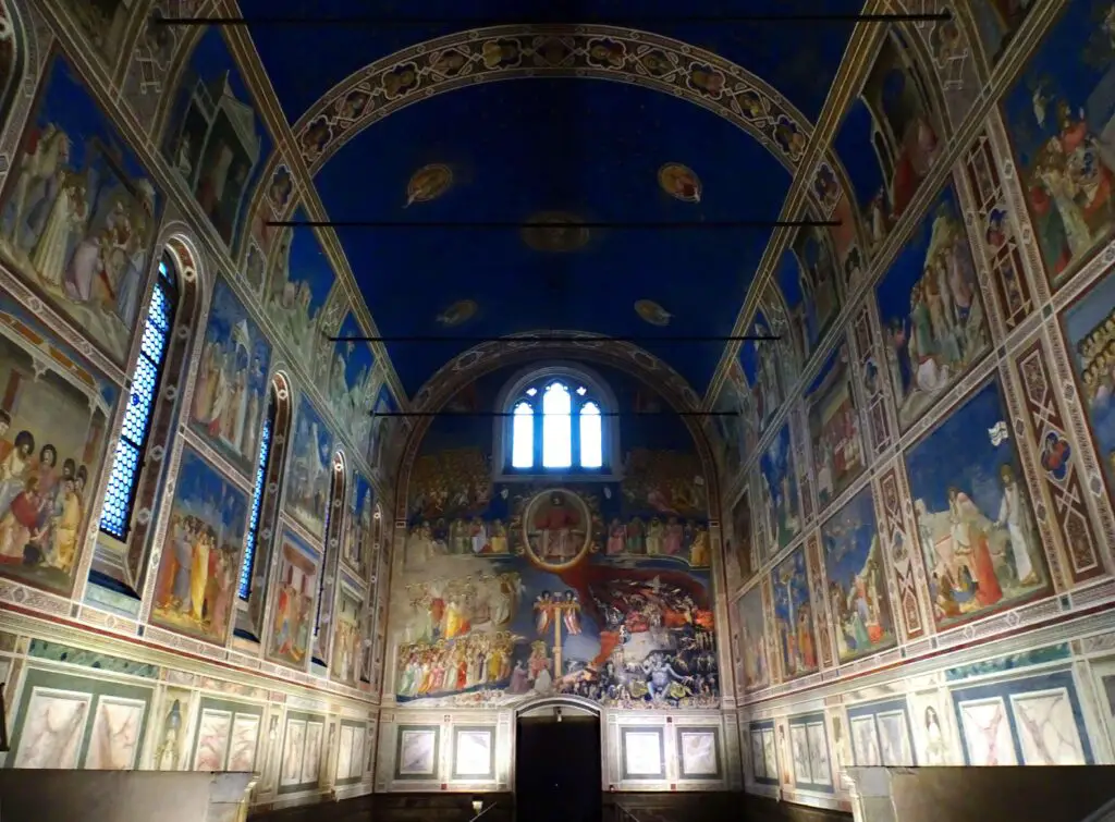 A chapel covered in countless frescoes with a blue-painted ceiling