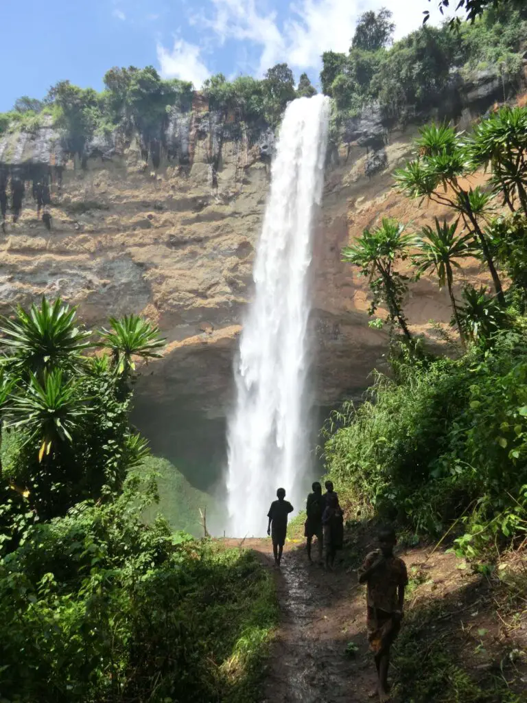 Children in front of a high single drop waterfall