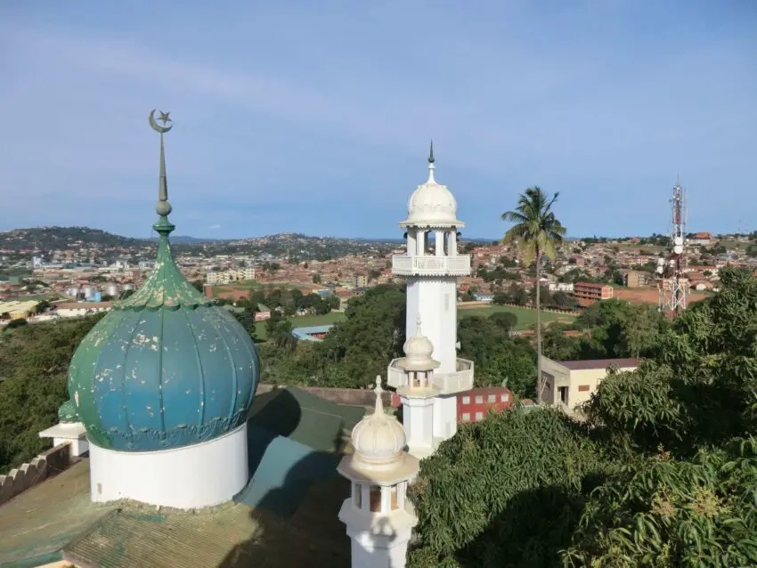 A city seen over the domes of a small white mosque