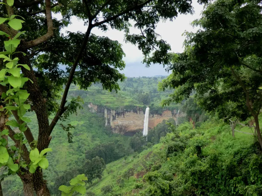 A tall waterfall suarounded by vegetation seen from far away