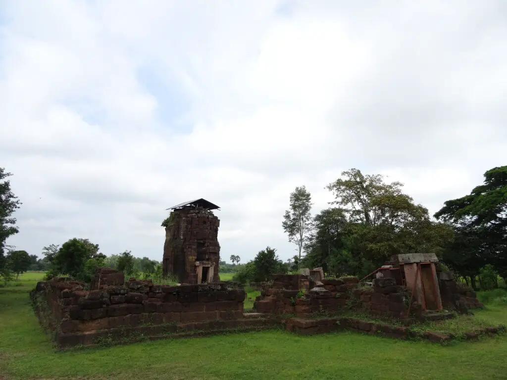 A small Khmer ruin surrounded by palm trees