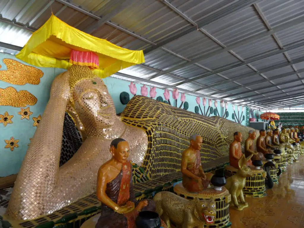 A reclining Buddha covered in beer bottles