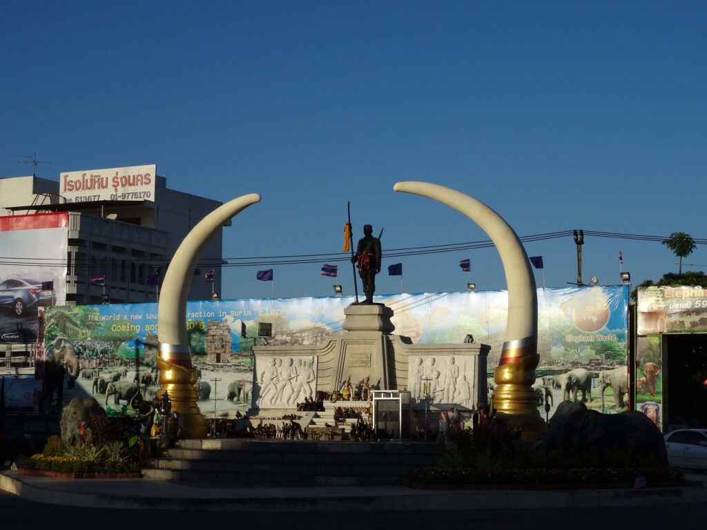 A statue of a man surrounded by large elephant tusks