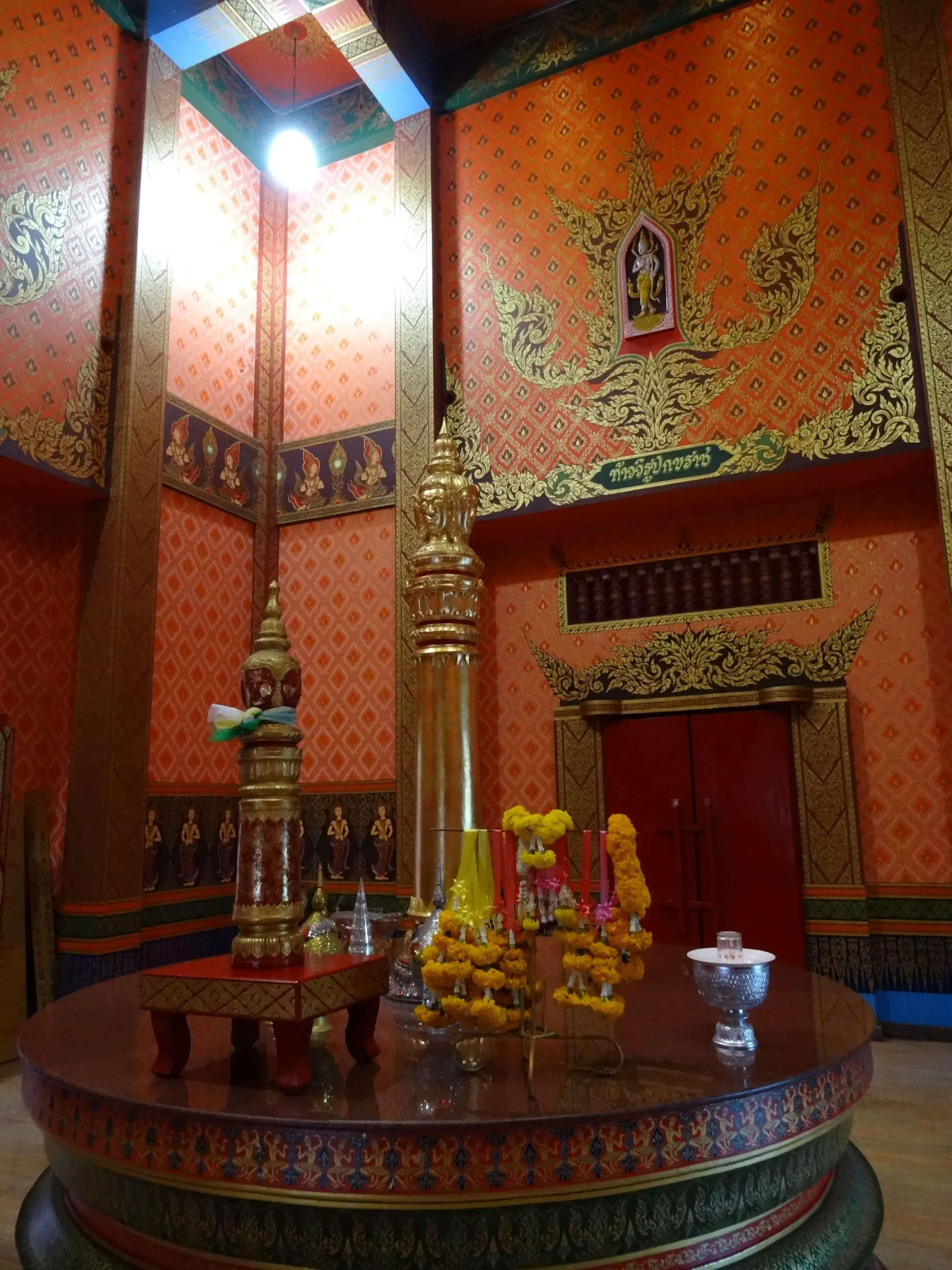 A golden pillar in an orange-painted room