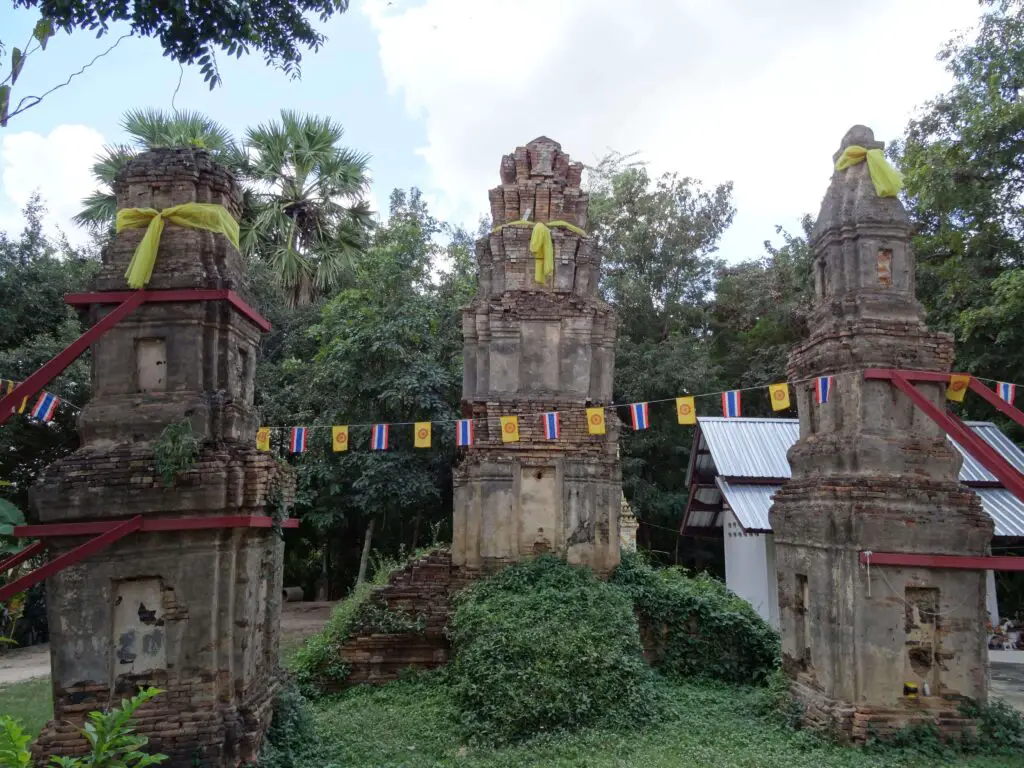 Three crumbling stone towers surrounded by tropical plants
