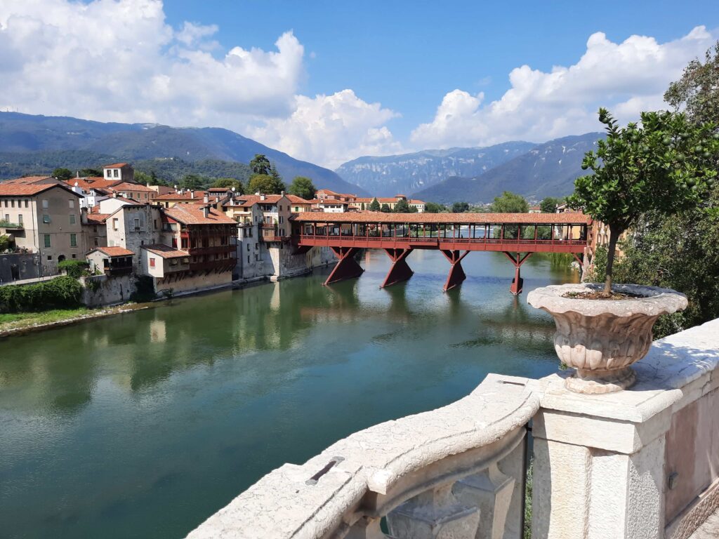 A pretty covered wooden bridge with some mountains in the background