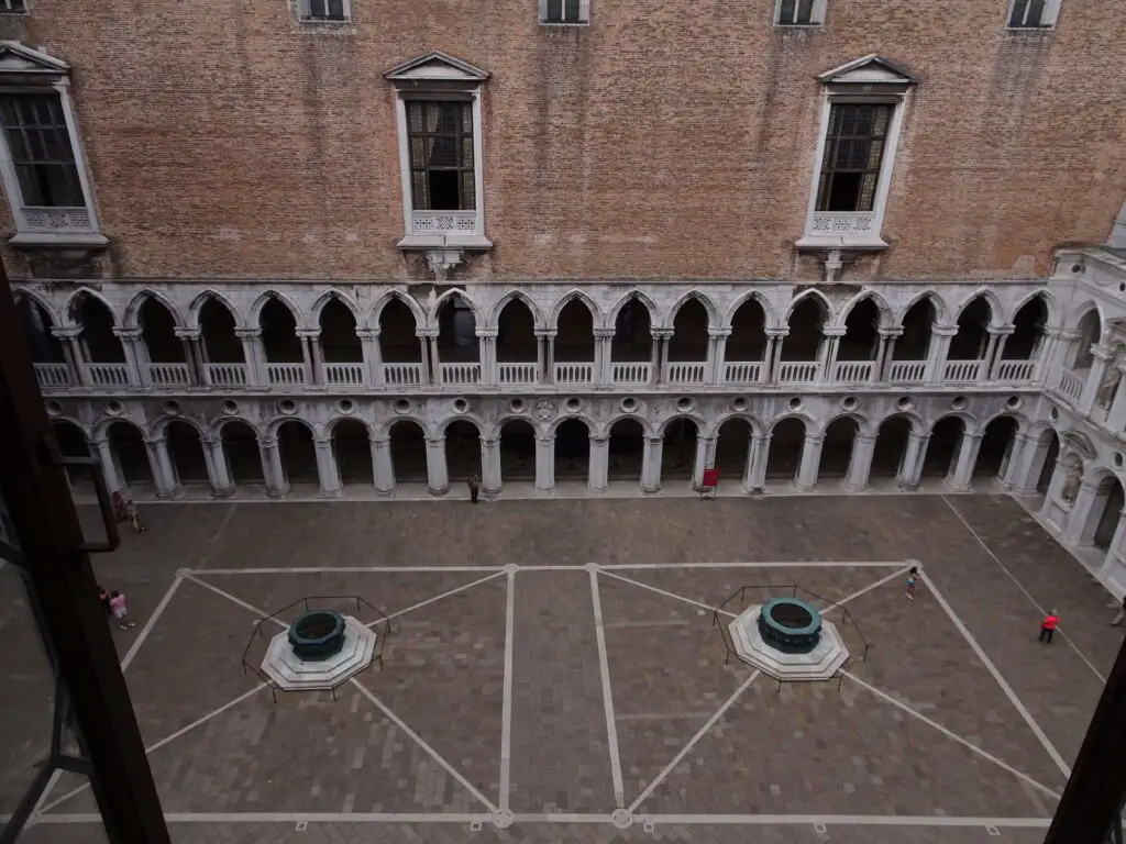 A courtyard and the facade of a palace seen from above