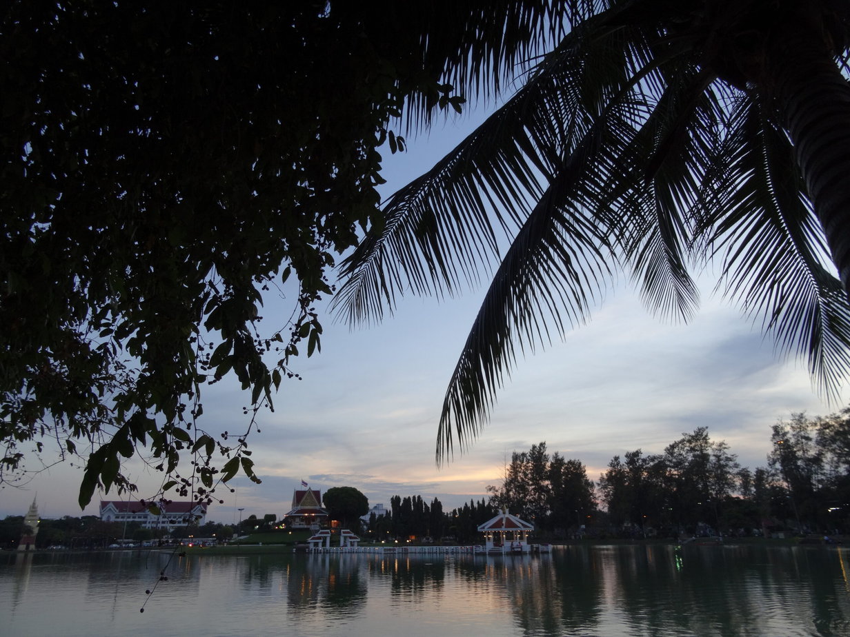 A view of a lake with a shrine building on an island in the centre at dusk.