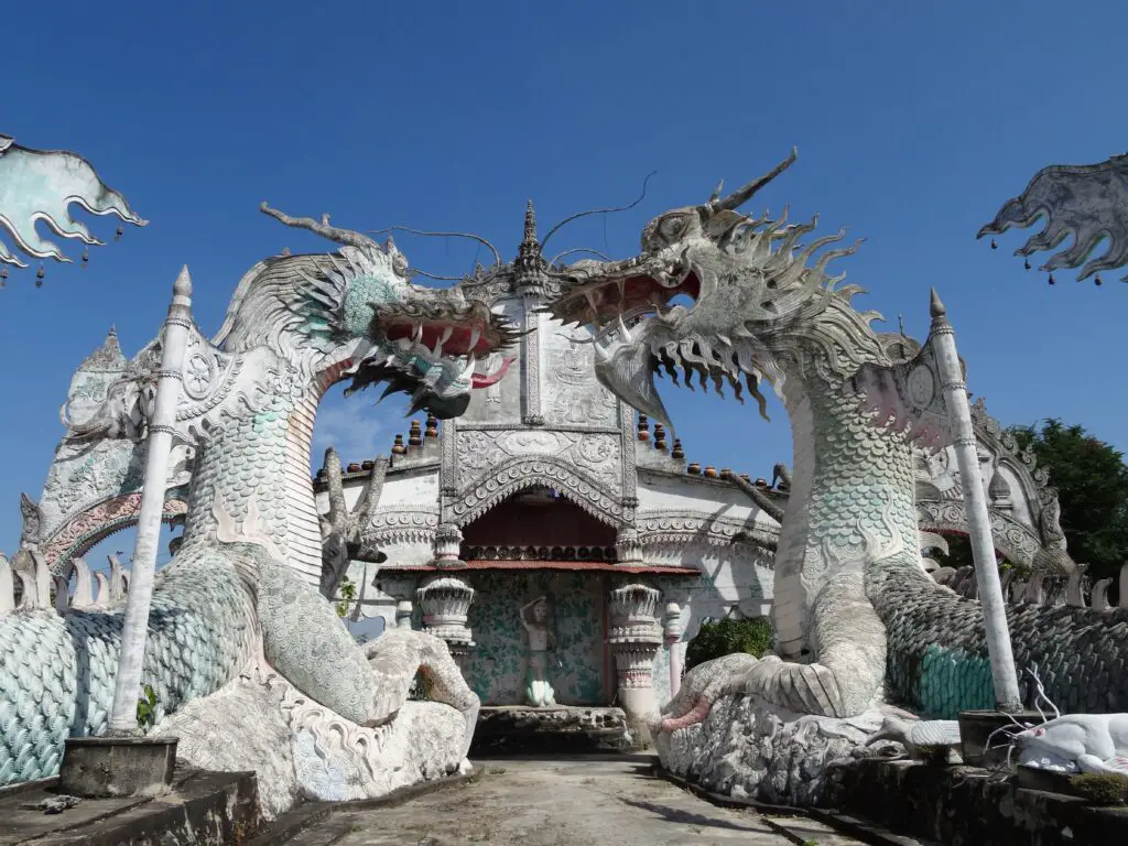 Two statues of giant white dragons looking at each other in front shrine