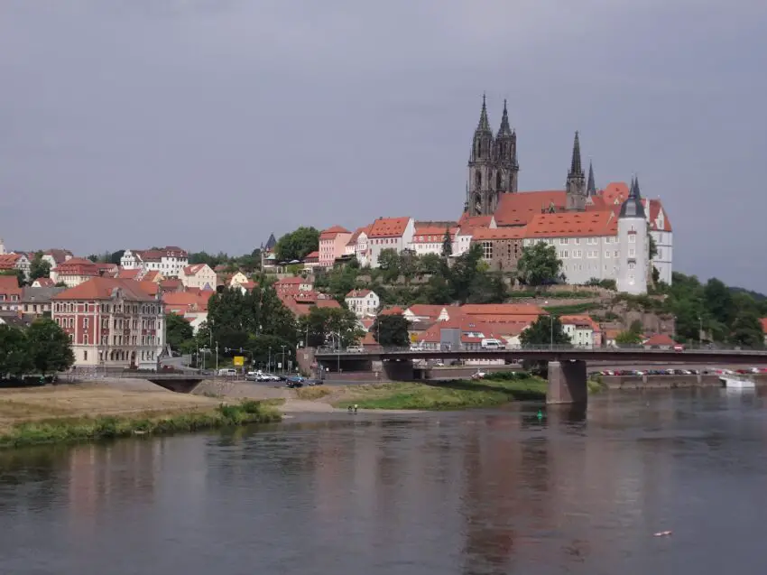 A renaissance castle and gothic cathedral on a hill over a broad river