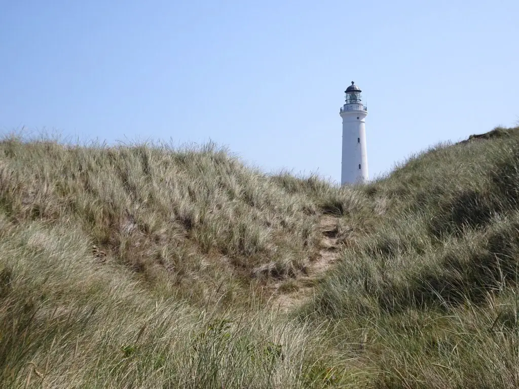 A lighthouse surrounded by dunes