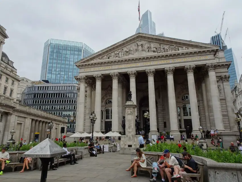 A tall stone building with a row of tall columns in front