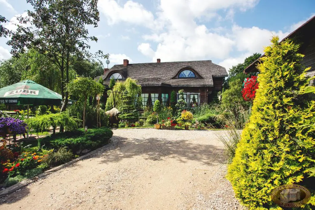 ein Haus mit einem Garten und einer Kieseinfahrt in der Unterkunft Kaktusik in Augustów