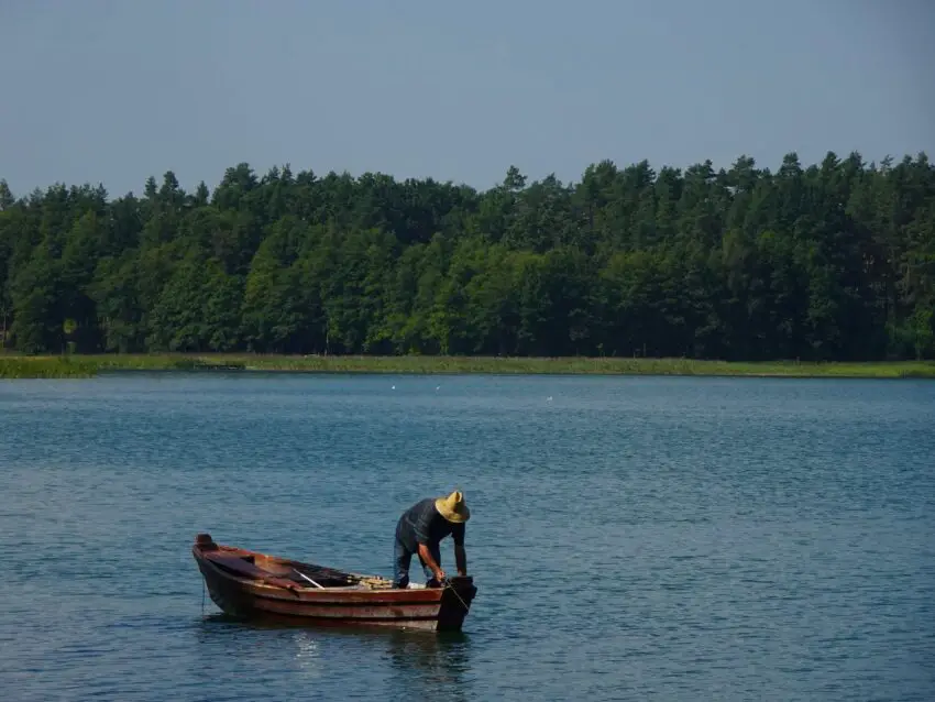 A fisher on a small boat on a lake