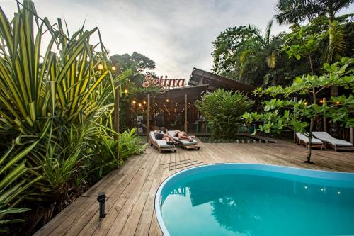 a couple laying on lounge chairs next to a swimming pool at Selina Red Frog in Bocas del Toro