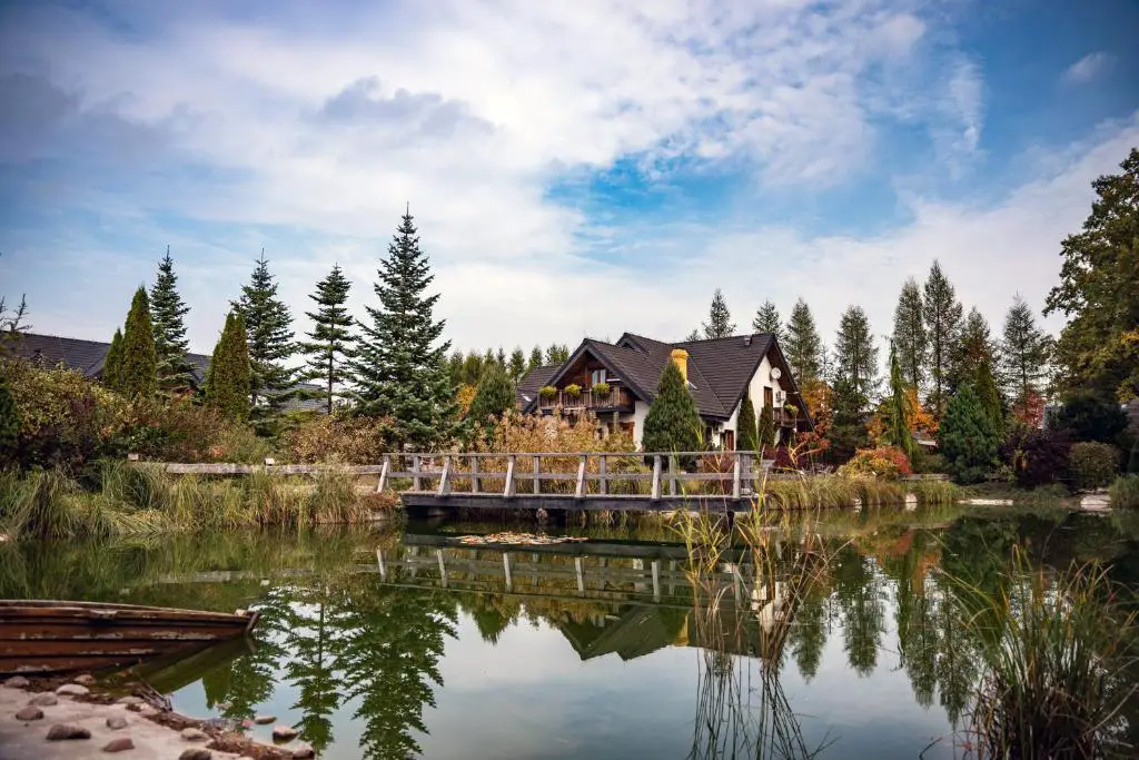 a house sitting on a bridge over a lake at Ostoja Wigierski in Mikolajewo