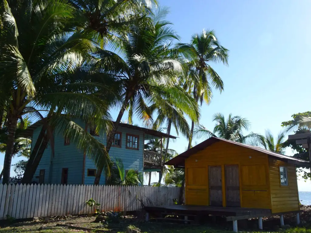 Brightly painted wooden houses surrounded by tropical vegetation