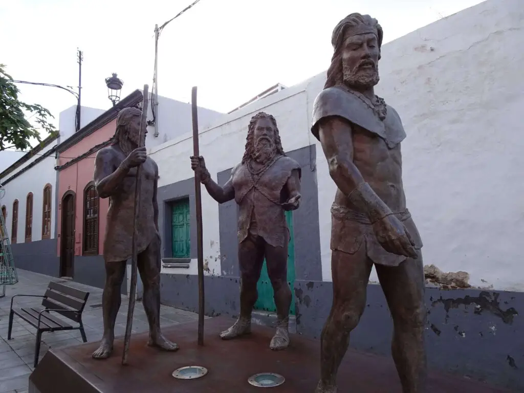 A statue depicting three bearded ancient canarians