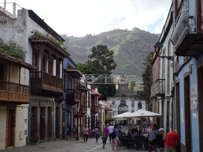 A pedestrianized street leading to a church with a mountain in the background