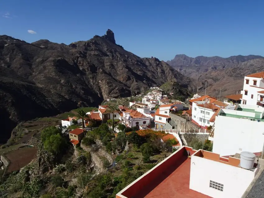 A row of white houses on a mountain slope, seen from above