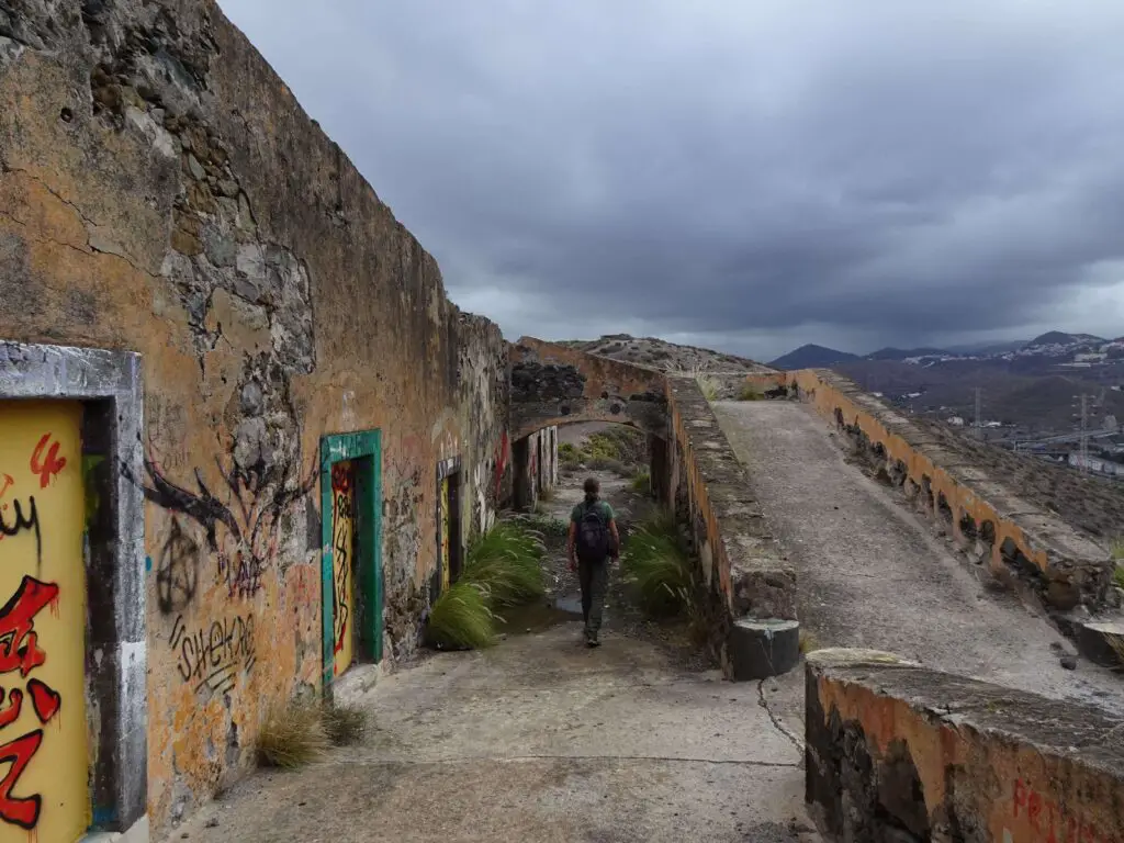 A man walking around the outside of an abandoned military battery