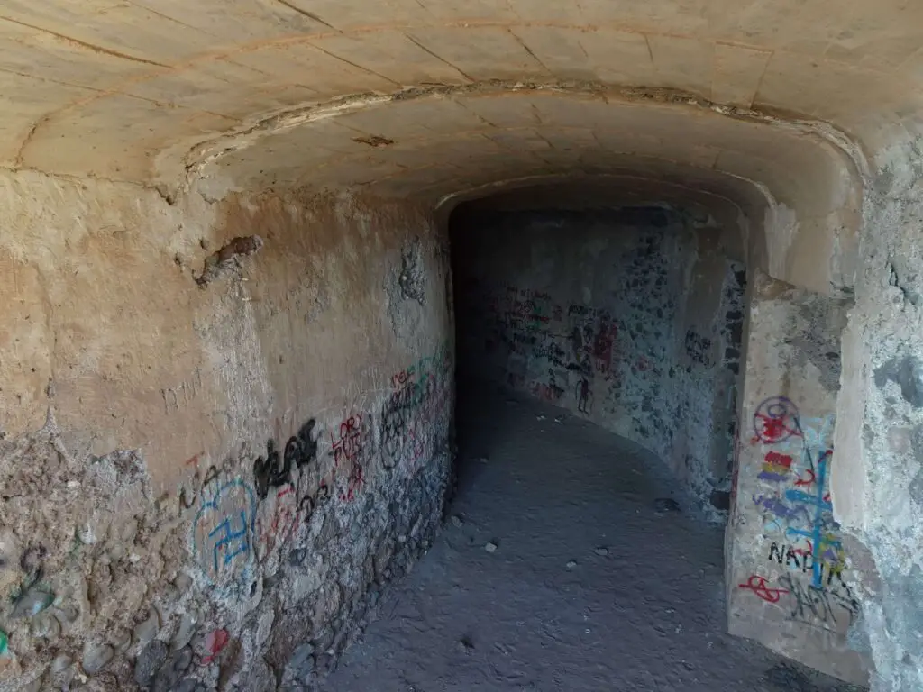 An old graffiti-covered tunnel leading into the darkness