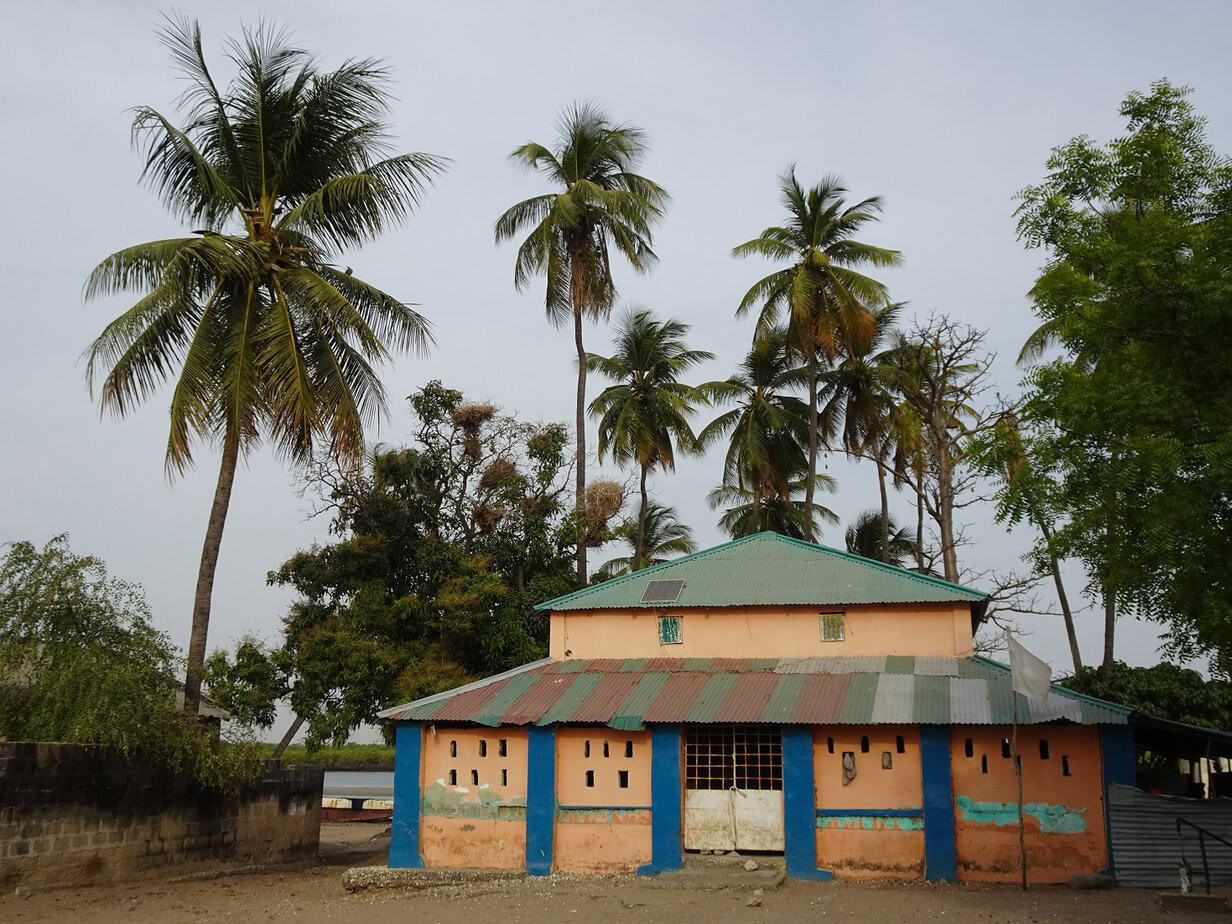 A colourful building with palm trees in the background