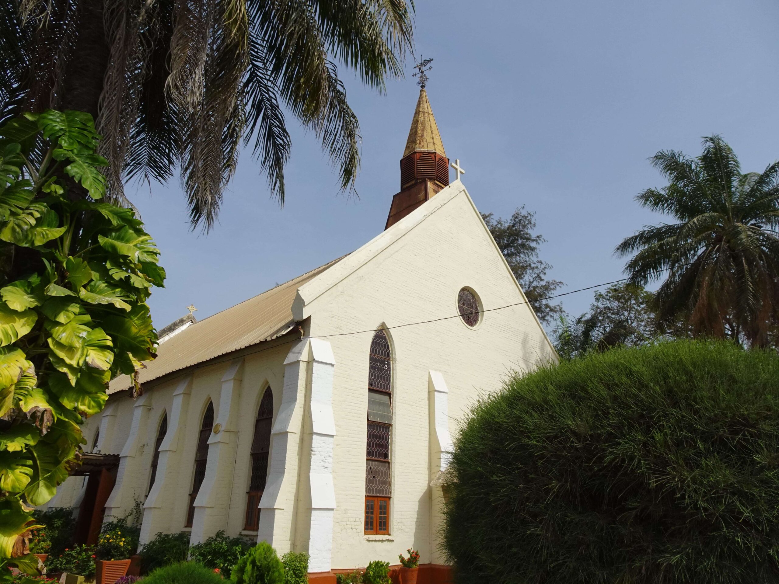 A church with a tower surrounded by tropical vegetation