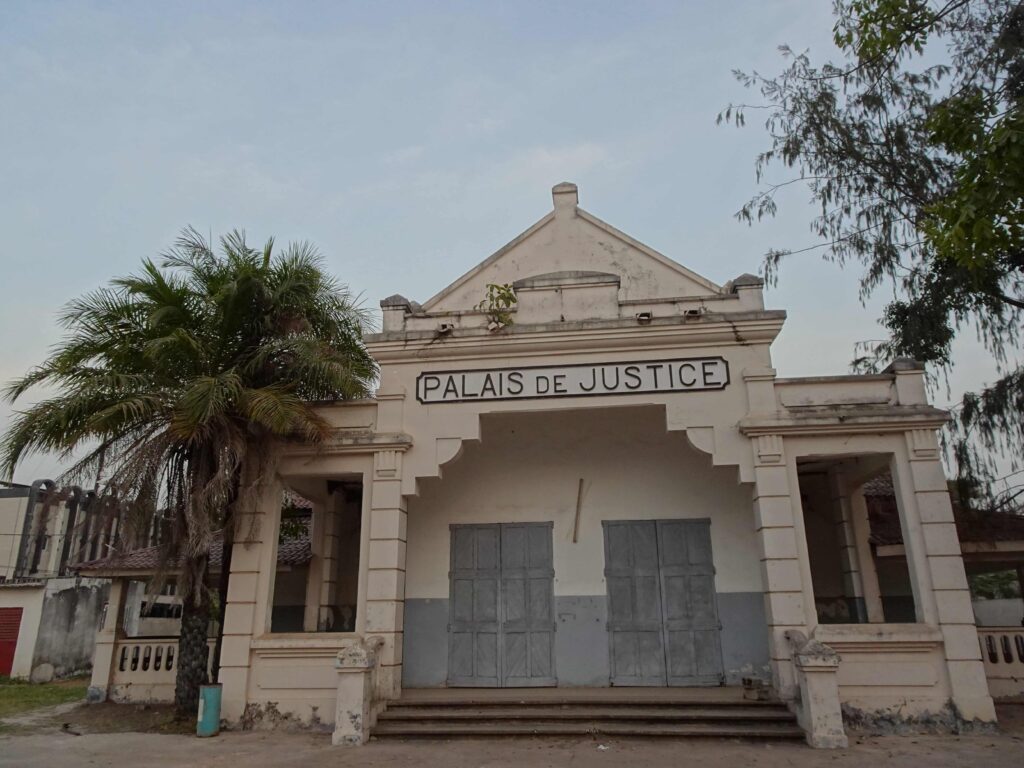 A colonial-era courthouse surrounded by palm trees