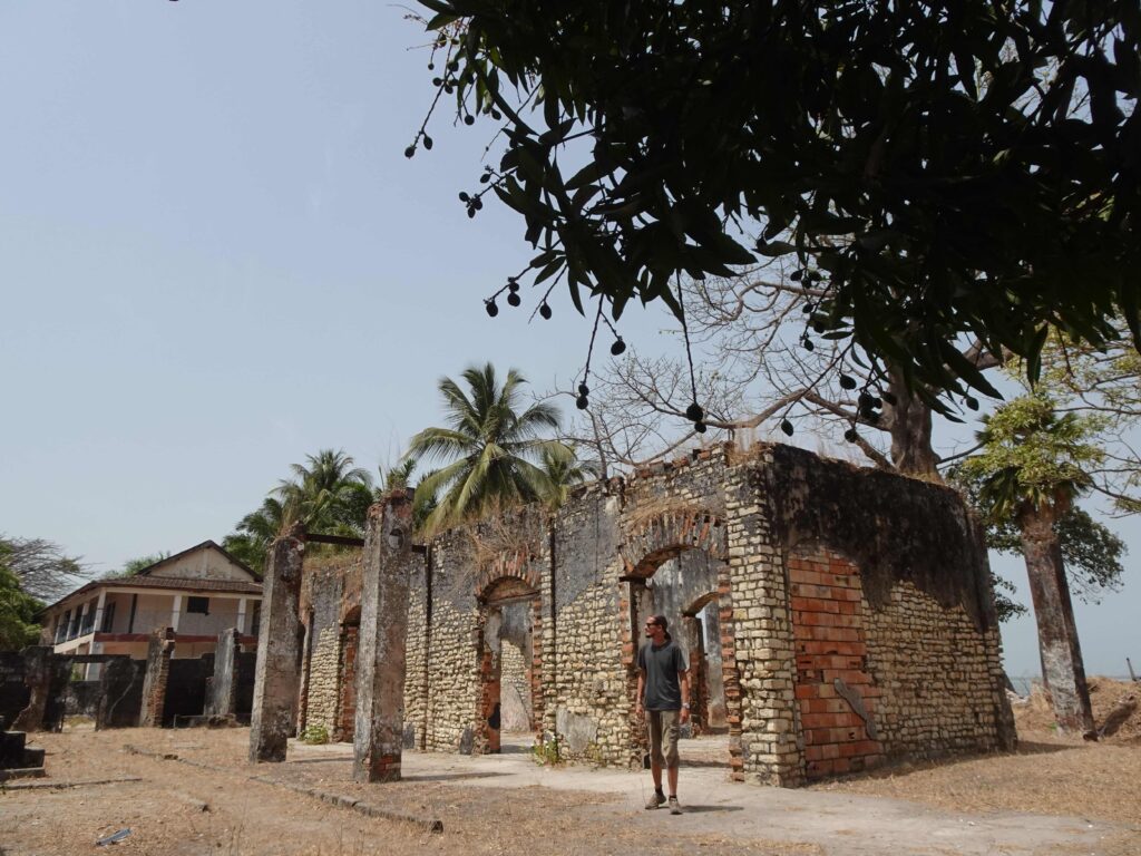 A man standing in front of a crumbling ruin
